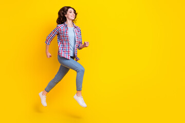 Fototapeta na wymiar Full size photo of good mood girlish woman curly hairstyle checkered shirt hurry run shopping isolated on yellow color background