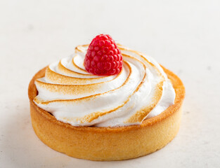 Lemon and meringue pie with ripe fresh raspberry on top of it