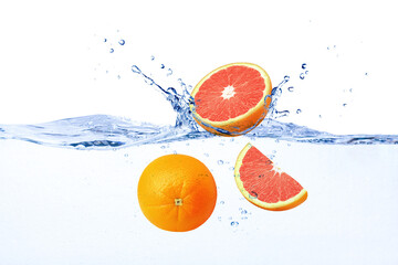 Fresh red grapefruit falling into blue water with splashing isolated on white background.