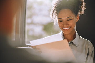 Joyful business lady examining documents in the office