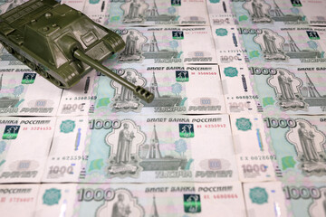 toy tank on russian banknotes roubles, war conflict russia ukraine, Sanctions, crisis, arms purchase concept