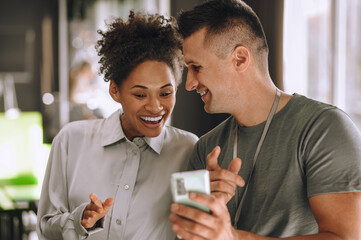 Employee demonstrating selfies to his cheerful colleague