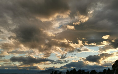 Grandi nuvole nere illuminate dal sole in cielo sopra i monti Appennini al tramonto