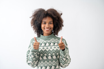 Portrait of young attractive african american woman with curly hair showing thumb up in studio on...