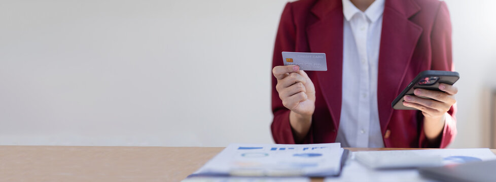 Hand woman using credit card and smartphone for buying online shopping, online payment, shopping online, e-commerce, internet banking, copy space, spending money.