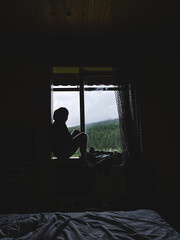 the girl is sitting on the windowsill