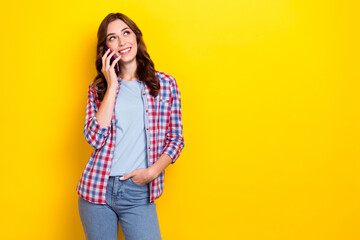 Photo of young dreaming lady wear checkered shirt talking conversation look empty space advertisement eshopping isolated on yellow color background