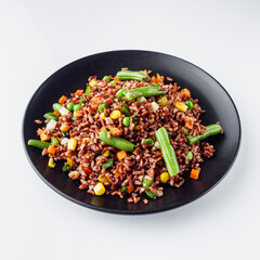 delicious red rice with vegetables on a white background