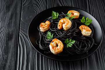 delicious black spaghetti pasta on a black rustic wooden background