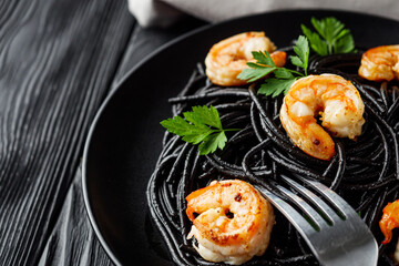 delicious black spaghetti pasta on a black rustic wooden background
