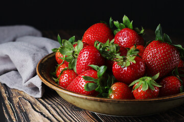 A bowl with ripe bright strawberry in rustic style
