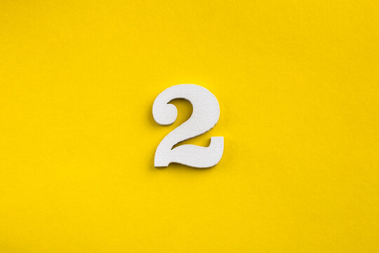 Number 2 - White wooden number on yellow background