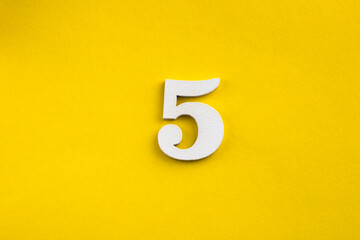 Number five - white number in wood on yellow background