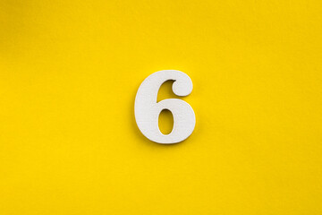 Number 6 - White wooden number on yellow background