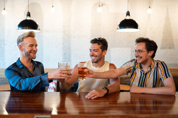 LGBTQ Friends sit at a bar with beer and champagne