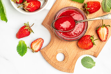 Jar of strawberry jam and fresh berries on wooden board white background. Long banner format