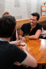 LGBTQ Friends sit at a bar with beer and champagne