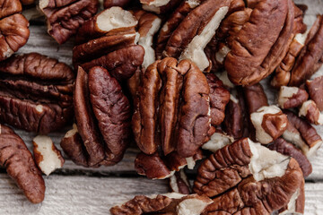 closeup of pecan nuts white wooden background