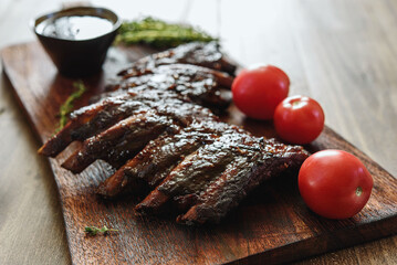 BBQ grilled pork ribs in Barbecue sauce on vintage wooden table background. Barbecue Pork Spare Ribs. Tasty snack to beer. American food concept. Selective focus - 548266202