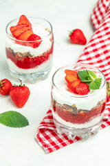 Two Glass of parfait with fresh fruit, yogurt and granola on white table. vertical image. top view. place for text