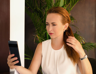 Woman sitting in cafe holding her telephone