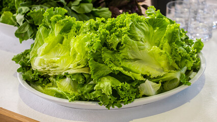 Fresh raw vegetables, lettuce, salad, on a modern white kitchen table. Healthy eating. Organic food.