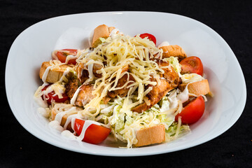 Fresh Caesar salad with chicken, parmesan cheese, lettuce, tomatoes and croutons.