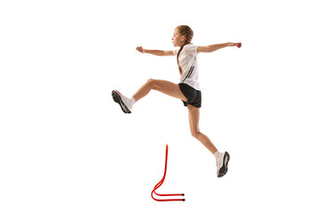 Dynamic portrait of little girl, professional athlete, runner, jogger at steeplechase training...