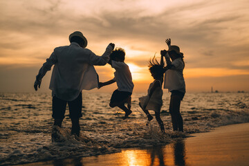 Silhouette of happy family at sunset on beach travel, Parents playing with child on beach, Family...
