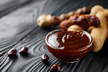 sweet and sour tamarind sauce on a black rustic wooden background