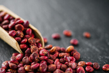 dry aromatic sumac spice on a black stone background