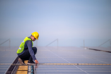 Asian Engineer checking solar power cell energy on rooftop of factory. Asian worker working install solar power solar cell system for using clean solar energy.