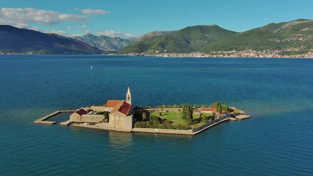 Aerial around view of the island of Notre Dame de la Misericorde, monastery in the Bay of Kotor, Montenegro. Ostrvo Gospa od Milosrda, 4k