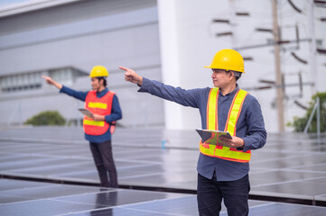 Asian engineer teamwork success standing happy in job working install on rooftop factory solar power solar cell energy.