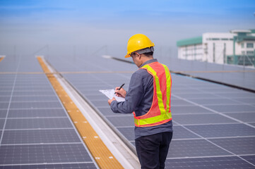 Obraz premium Asian Engineer checking solar power cell energy on rooftop of factory. Asian worker working install solar power solar cell system for using clean solar energy.