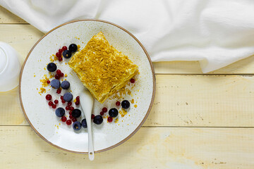 Napoleon cake with berries on a wooden table