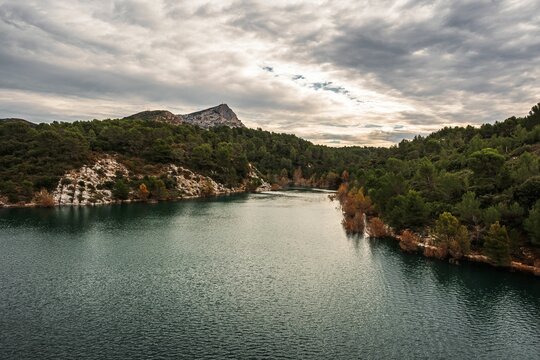 Landscape of the Lac Zola Lake with a green forested shore on a cloudy day