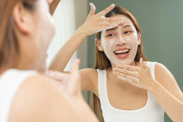 Cheerful asian young woman, beauty girl hand applying foam cleanser for washing on her face, clean...