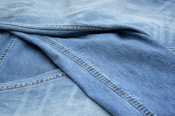 Lots of jeans pants in a stack. Denim background.