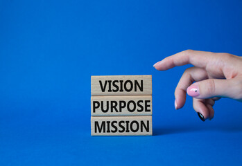 Vision Purpose Mission symbol. Concept word Vision Purpose Mission on wooden blocks. Beautiful blue background. Businessman hand. Business and Vision Purpose Mission concept. Copy space.