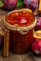 Jar with homemade plum jam on a wooden background. banner, menu, recipe place for text