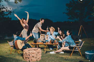 Young hipster people having fun to music dining and drinking together in campsite - Travel vacation...