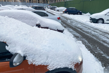 Snowy. Cars covered with snow. Winter problems of car drivers. Clearing car from snow.