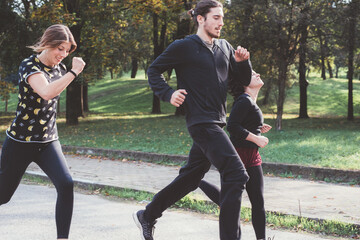 Obraz premium Three runners sprinting outdoors training in a park area together