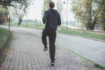 Backview young man outdoor jogging running park