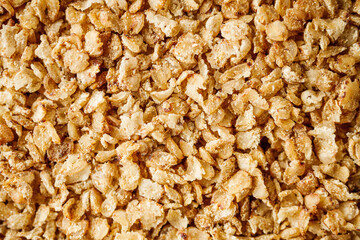 fresh raw buckwheat flakes on a black wooden background