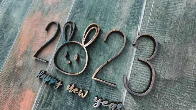 3D animation of 2023 Happy New Year glow silver chrome text with rabbit face cinematic title. Ending cover for end scence trailer winter snow, Christmas and New year event background