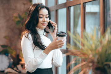 freelance business woman using smartphone or mobile phone to work on online communication technology, young Asian businesswoman or female entrepreneur with laptop computer to working on cyberspace