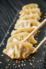 delicious fried gyoza dumplings on a black plate