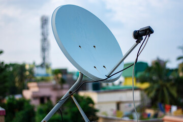 Satellite dish antenna on top of the building in urban area at daytime..